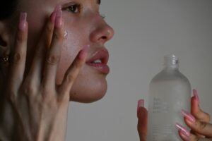 Woman applying cream to her face