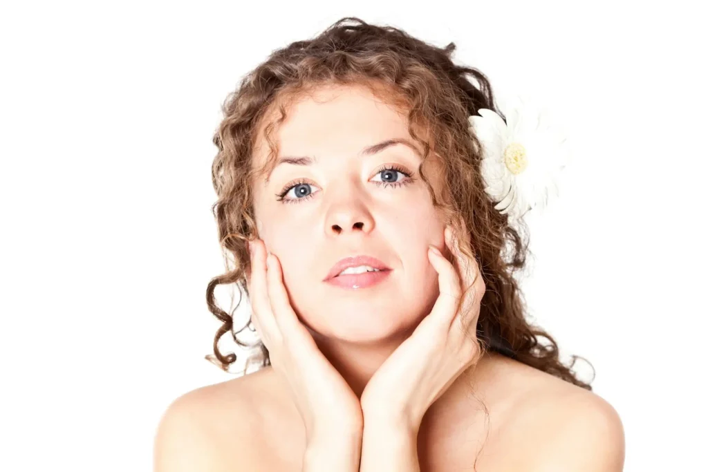 Close-up of a woman with clear, hydrated skin resting her face in her hands, symbolizing skin barrier repair, hydration support, and strengthened skin protection.