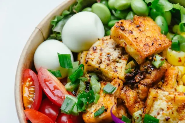 High-protein meal with grilled chicken, boiled eggs, edamame, and fresh vegetables, illustrating nutritious protein-rich foods for weight loss and appetite control.