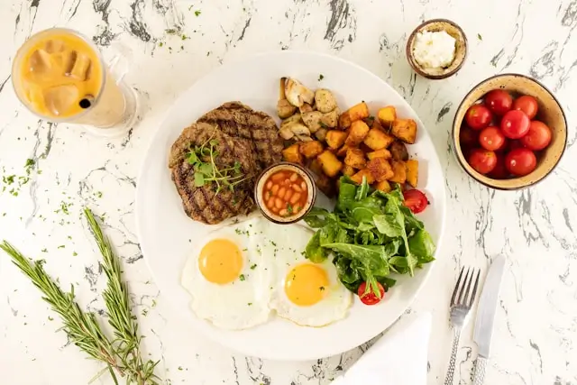 Balanced high-protein meal with lean beef, eggs, roasted vegetables, leafy greens, and beans, demonstrating how to increase protein intake for healthy weight loss.