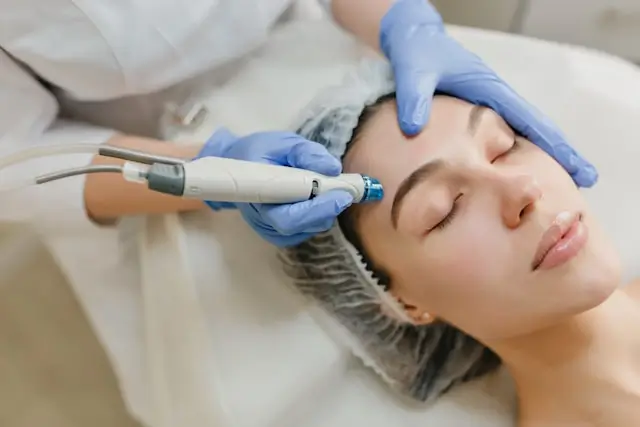 Woman receiving a professional facial treatment with a handheld skincare device, illustrating how individual factors such as skin condition, treatment approach, and lifestyle may influence how people respond differently to collagen supplementation.