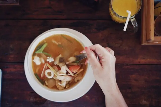 A warm bowl of homemade bone broth served on a rustic wooden table, representing natural collagen and nutrient-rich traditional food.