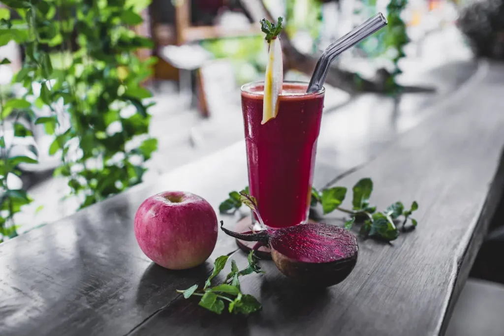 Glass of fresh beetroot juice with apple and mint on a wooden table, symbolizing natural detox drinks and real results from liver support supplements like Liv Pure review results, for metabolism and weight management.