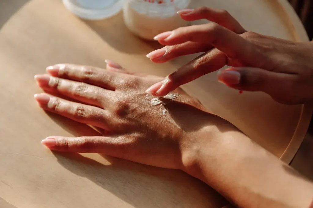Woman applying skincare cream to her hand, representing anti-aging skincare ingredients that actually work for reducing wrinkles, improving hydration, and supporting youthful skin naturally.