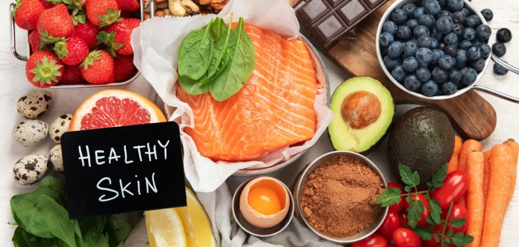 Healthy skin foods such as salmon, blueberries, avocado, leafy greens, eggs, citrus fruits, and antioxidant-rich ingredients, representing foods for glowing skin, collagen support, and a radiant complexion.