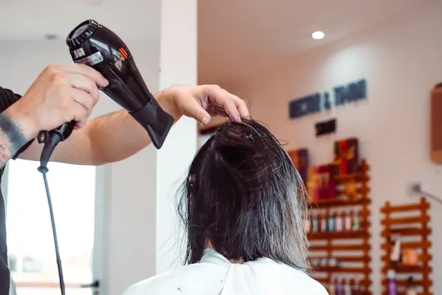 Hairdresser examining a client's scalp.