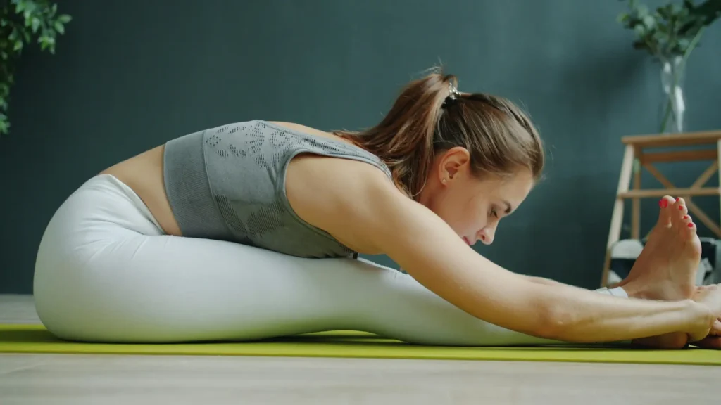 Woman practicing seated yoga stretching as part of a detox fitness guide to support flexibility, muscle recovery, posture, and healthy aging.